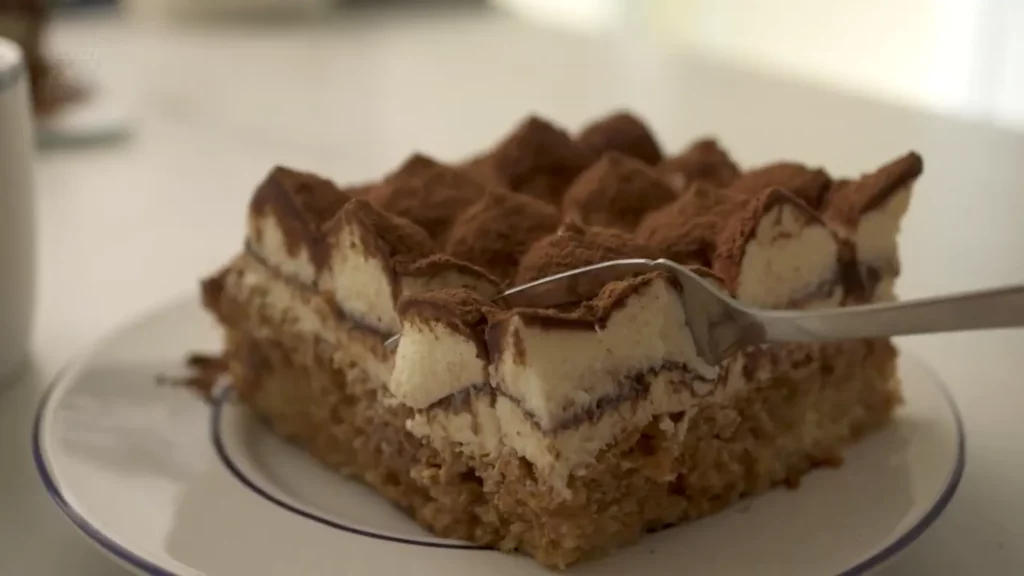 Tranche de tiramisu mise en avant avec une cuillère