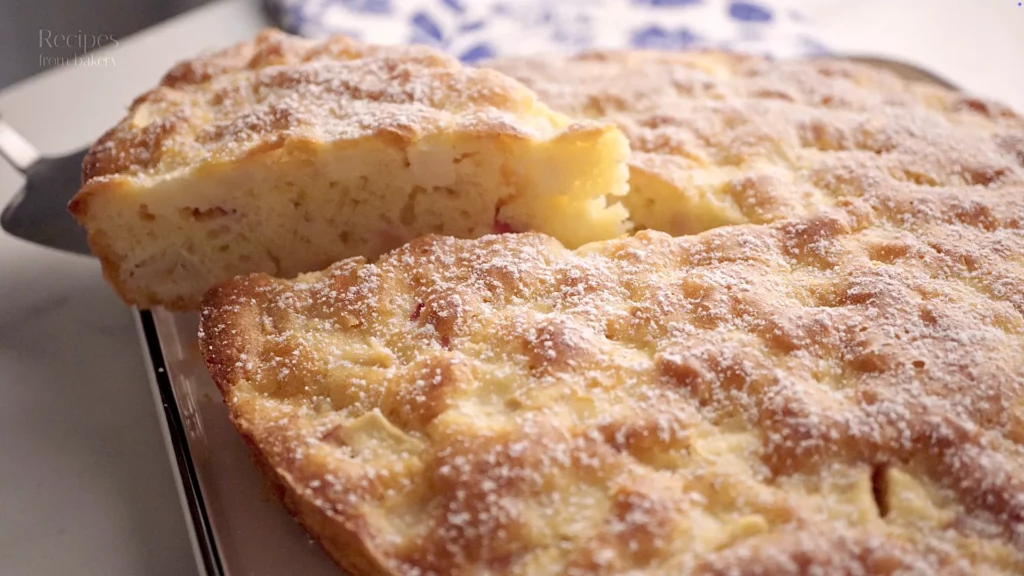 Gâteau aux pommes entier sur une assiette, avec une part retirée