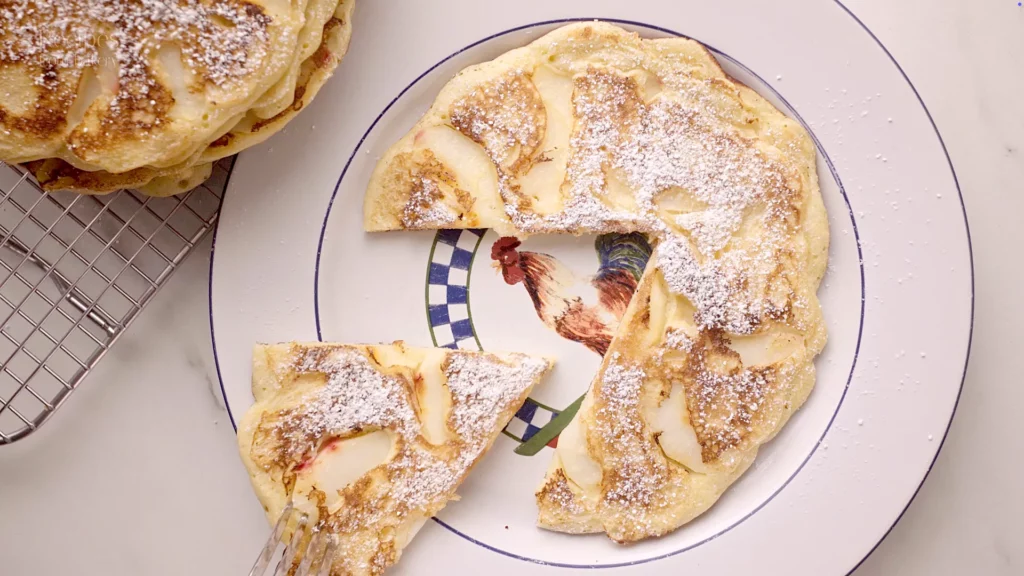 Gâteau de pancakes coupé montrant des morceaux de pomme fondants