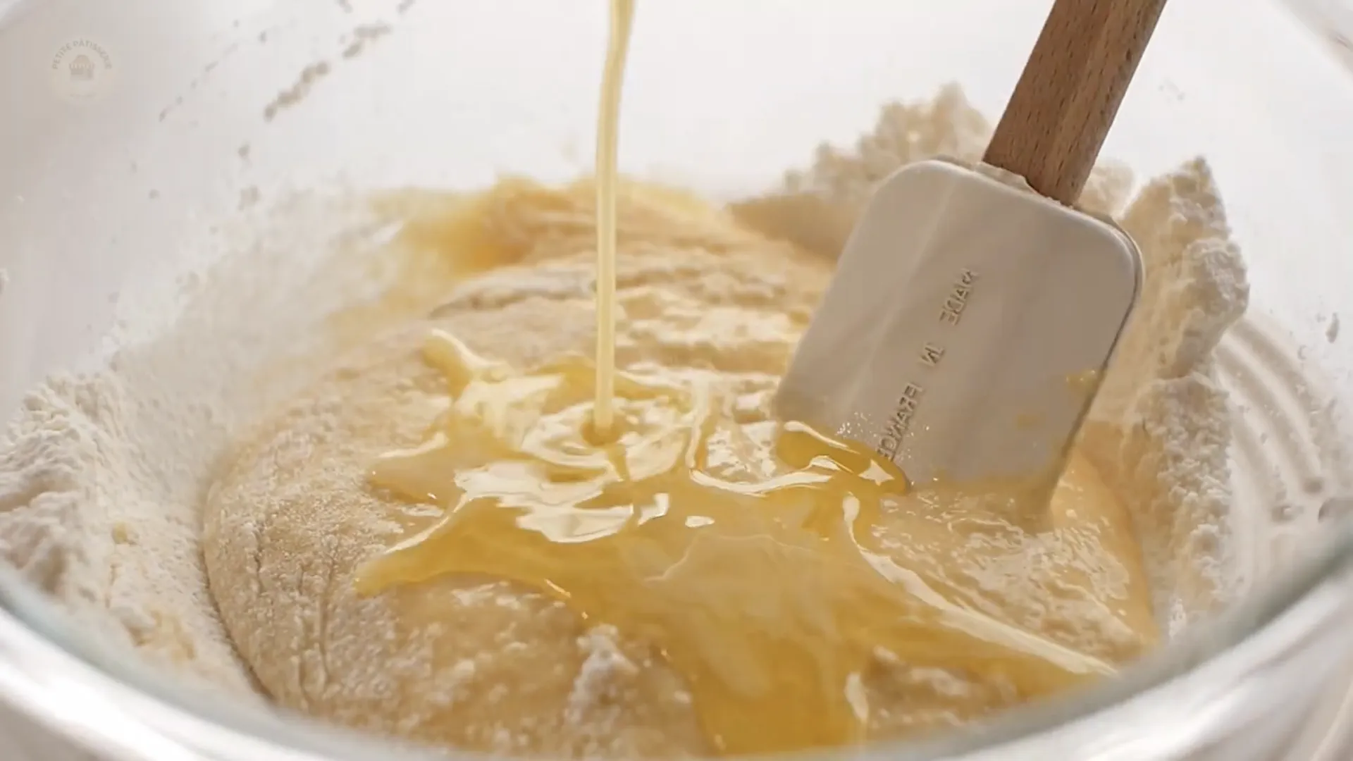 Versement progressif du beurre fondu dans la pâte à crêpes