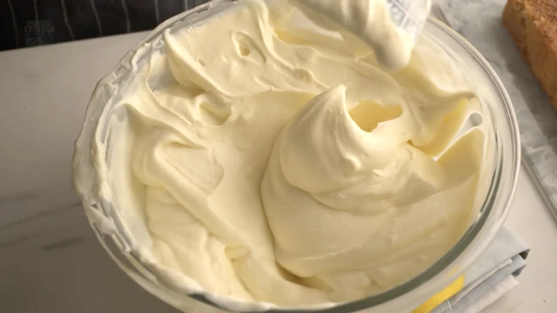 Crème mascarpone dans un bol en verre avec spatule en silicone