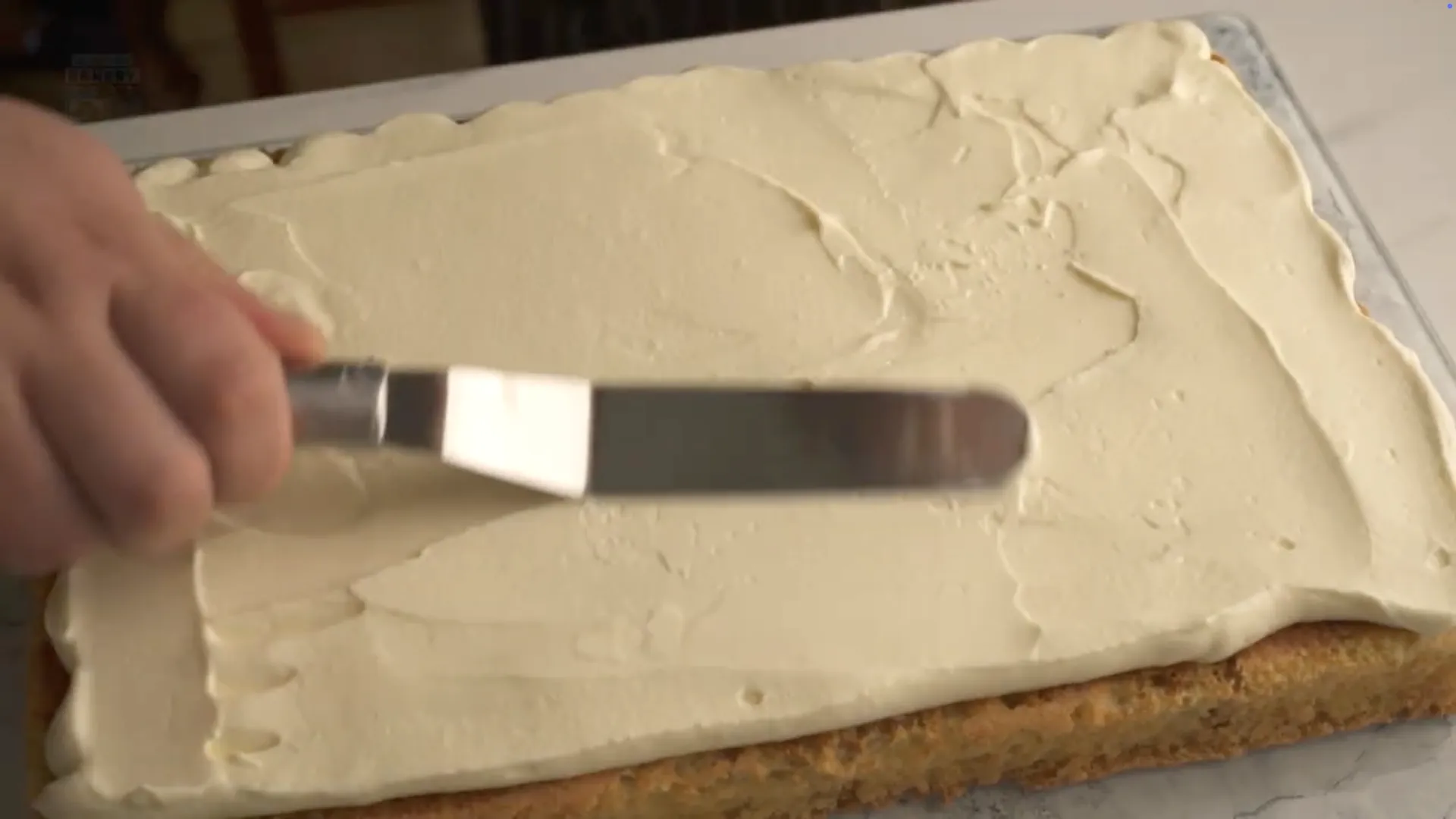 Spatule étalant uniformément la crème sur la génoise