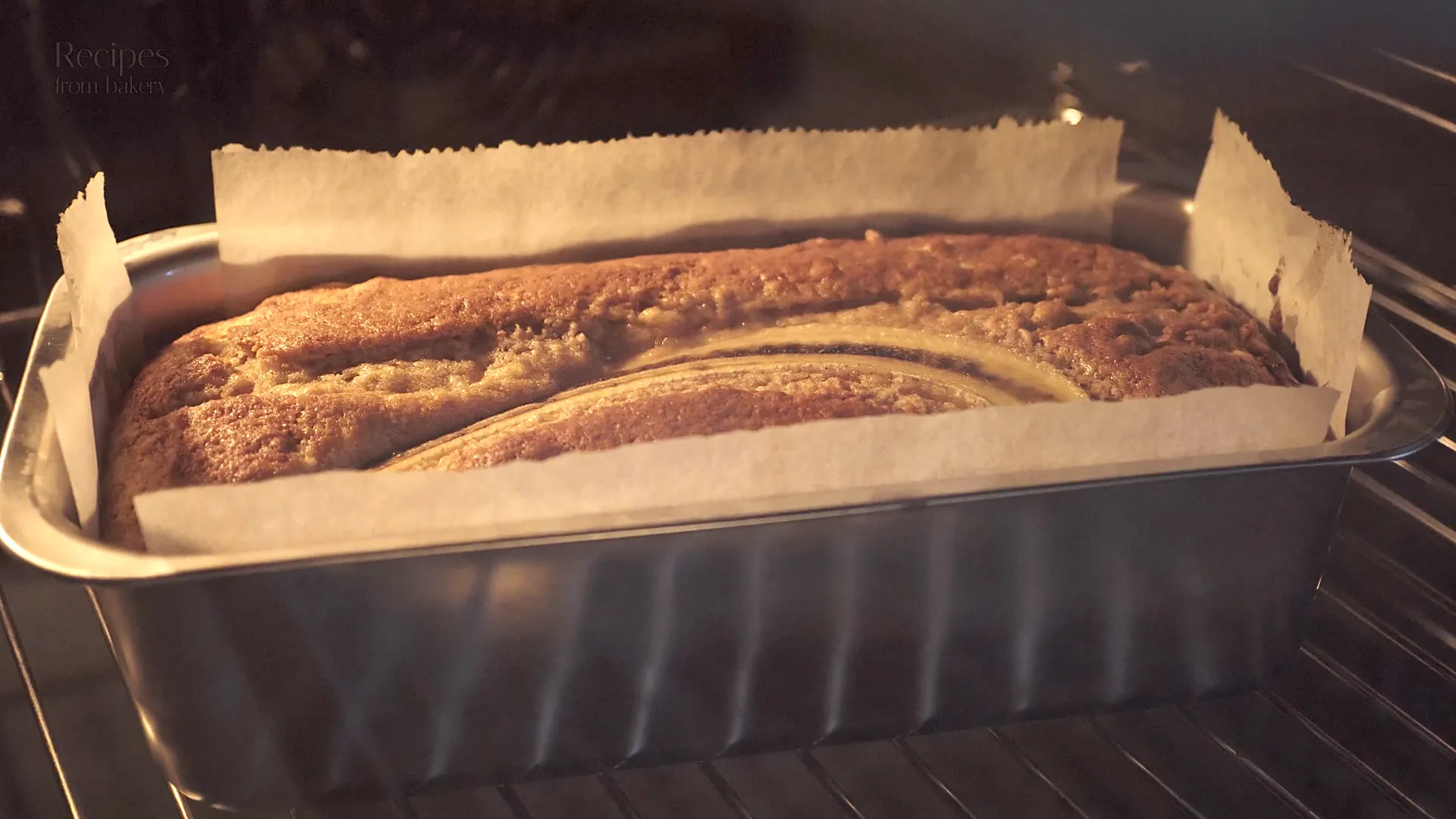 Cake à la banane en train de cuire au four, vu à travers la vitre.