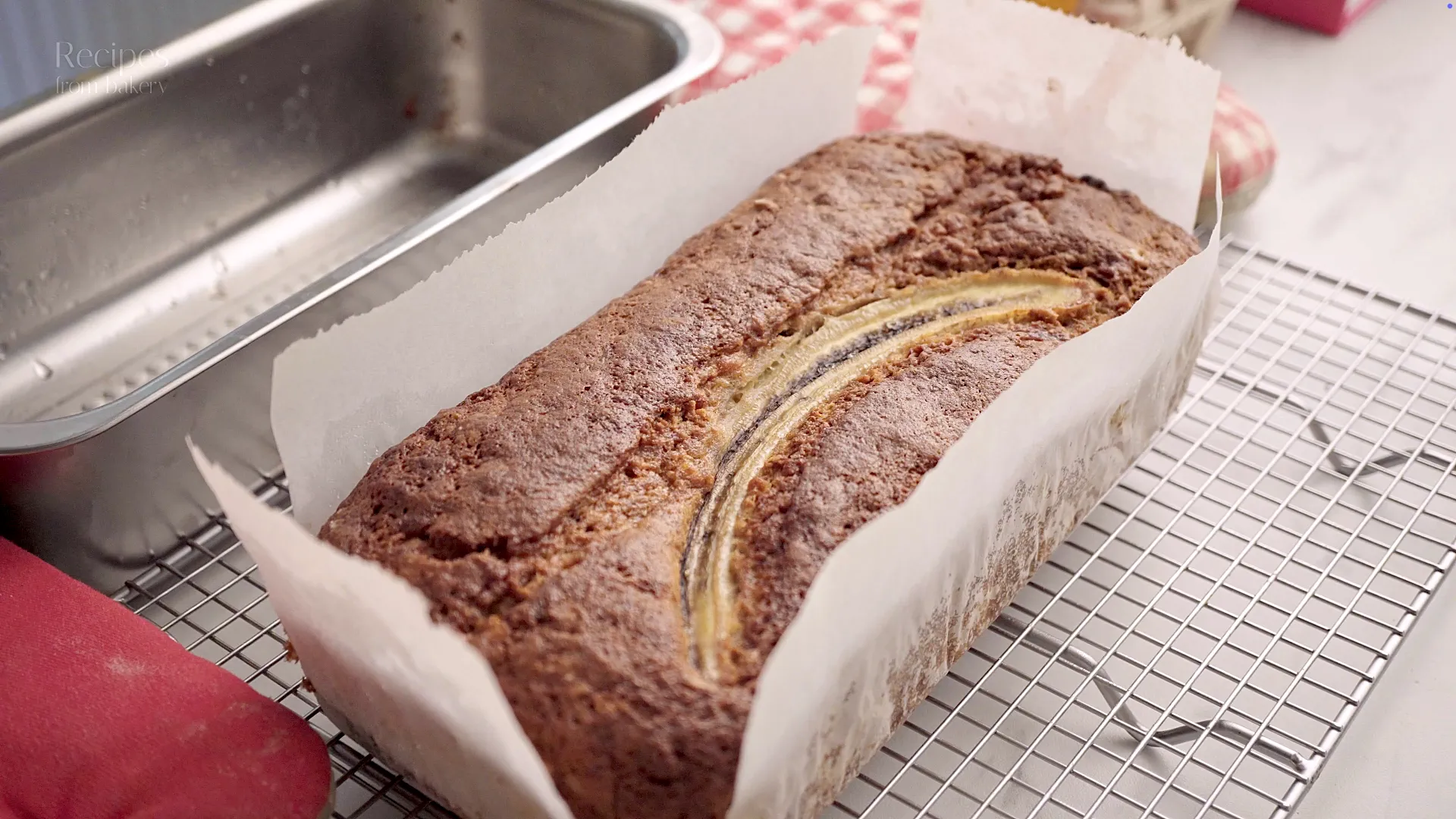 Cake à la banane encore chaud, posé sur du papier cuisson.