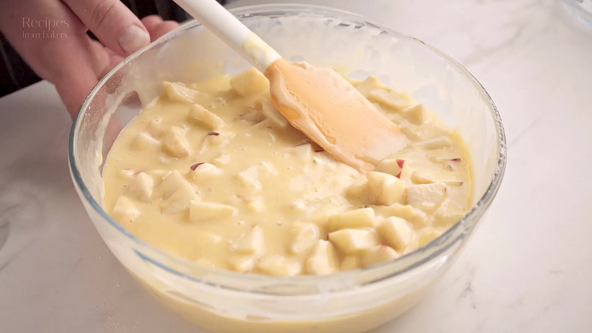 Incorporation des pommes dans la pâte à gâteau à l’aide d’une spatule